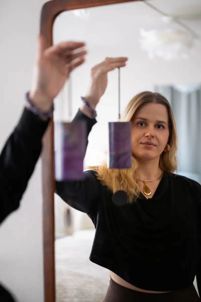 Alex med klokkespil ved et spejl hos manualtherapies på Frederiksberg.
